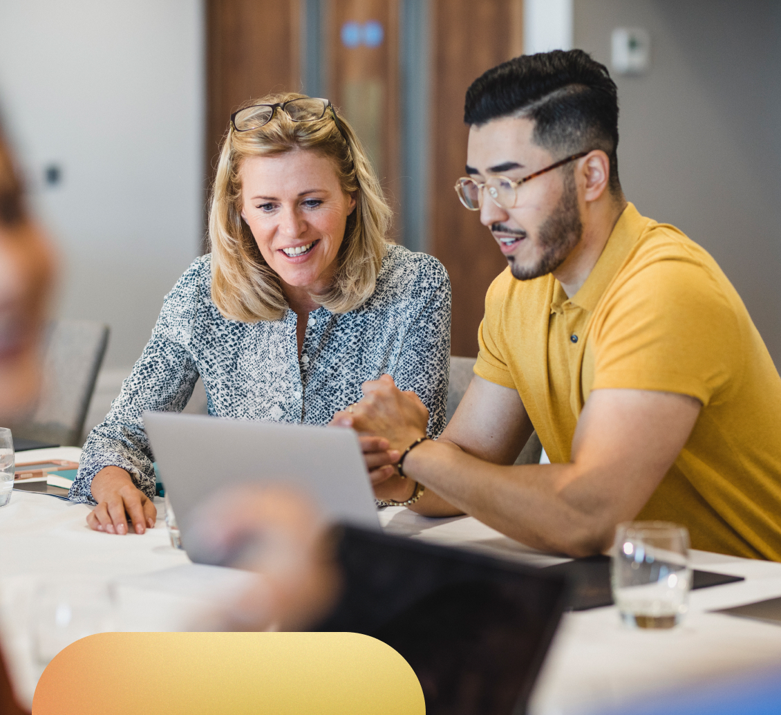 Image of a smiling teacher assisting her students.