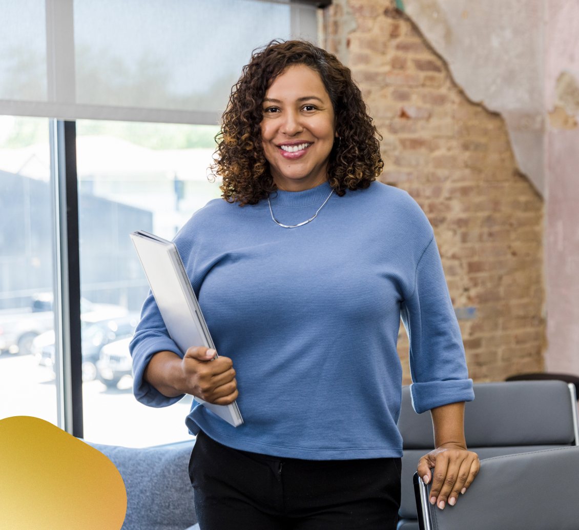 Image of a smiling teacher assisting her students.